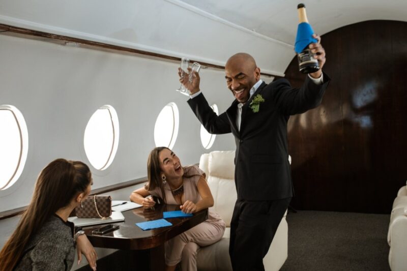 三名乘客在头等舱飞机笑他们想喝酒